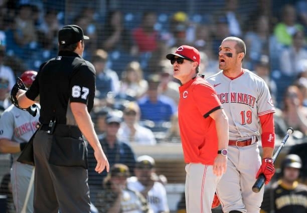 Joey Votto of the Cincinnati Reds and manager David Bell yell at umpire Ryan Additon after a call during the first inning of a baseball game against...