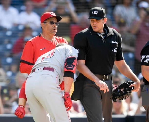 Joey Votto of the Cincinnati Reds puts his shoulder into umpire Ryan Additon after a call during the first inning of a baseball game against the San...