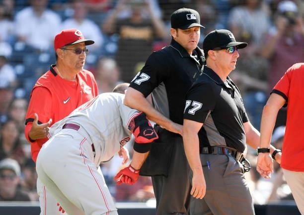 Joey Votto of the Cincinnati Reds puts his shoulder into umpire Ryan Additon after a call during the first inning of a baseball game against the San...