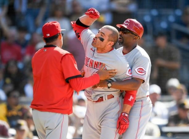 Joey Votto of the Cincinnati Reds is held back as he yells at umpire Ryan Additon after a call during the first inning of a baseball game against the...
