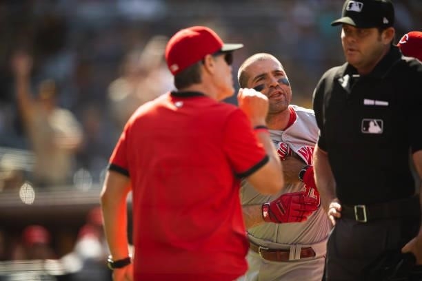 Joey Votto of the Cincinnati Reds is held back while arguing with the home plate umpire after being ejected against the San Diego Padres on June 19,...
