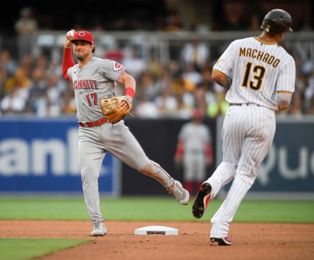 Kyle Farmer of the Cincinnati Reds throws past Manny Machado of the San Diego Padres to turn a double play during the seventh inning of a baseball...