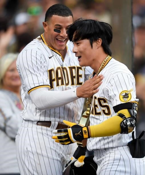 Ha-Seong Kim of the San Diego Padres is congratulated by Manny Machado after hitting a two-run home run during the eighth inning of a baseball game...