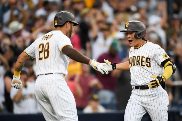 Ha-Seong Kim of the San Diego Padres is congratulated by Tommy Pham after hitting a two-run home run during the eighth inning of a baseball game...