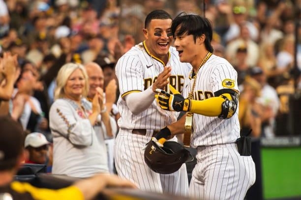 Manny Machado places the 'swag chain' on Ha-seong Kim of the San Diego Padres after Kim's home run in the eighth inning against the Cincinnati Reds...