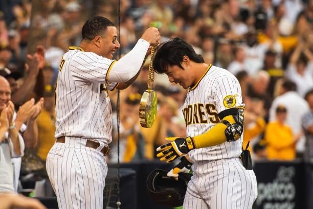 Manny Machado places the 'swag chain' on Ha-seong Kim of the San Diego Padres after Kim's home run in the eighth inning against the Cincinnati Reds...