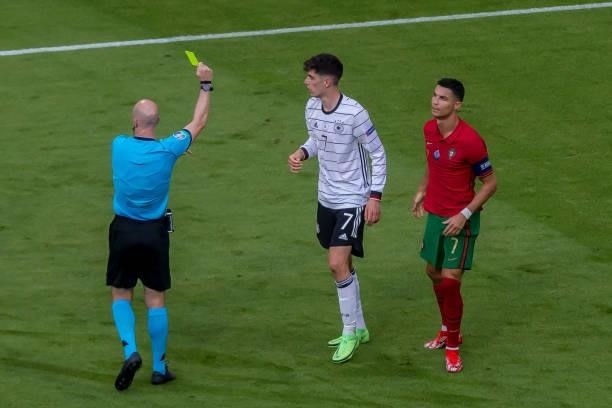 Referee Anthony Taylor and Kai Havertz of Germany gets the yellow card during the UEFA Euro 2020 Championship Group F match between Portugal and...