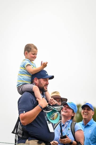 Thiel Rose and his father Casey Rose smile after receiving a ball from Phil Mickelson on the 13th hole during the third round of the 121st U.S. Open...