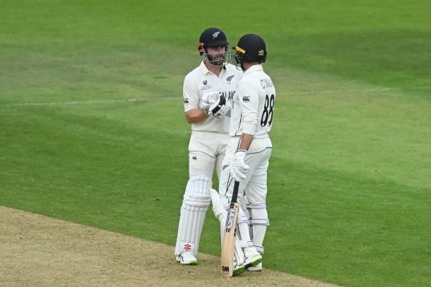 New Zealand's captain Kane Williamson congratulates New Zealand's Devon Conway after he reaches his half century on the third day of the ICC World...