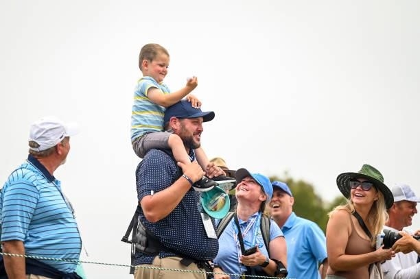 Thiel Rose and his father Casey Rose smile after receiving a ball from Phil Mickelson on the 13th hole during the third round of the 121st U.S. Open...