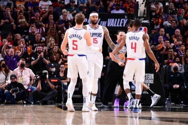 DeMarcus Cousins of the LA Clippers high fives Luke Kennard of the LA Clippers and Rajon Rondo of the LA Clippers during the game against the Phoenix...