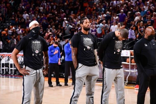 Jay Scrubb of the LA Clippers, Paul George of the LA Clippers and Nicolas Batum of the LA Clippers listen to the national anthem before the game...