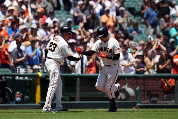 Third base coach Ron Wotus of the San Francisco Giants celebrates with Wilmer Flores after Flores hit a home run during the game between the...