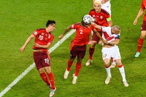 Kevin Mbabu of Switzerland battles for the ball with Burak Yilmaz of Turkey during the UEFA Euro 2020 Championship Group A match between Switzerland...