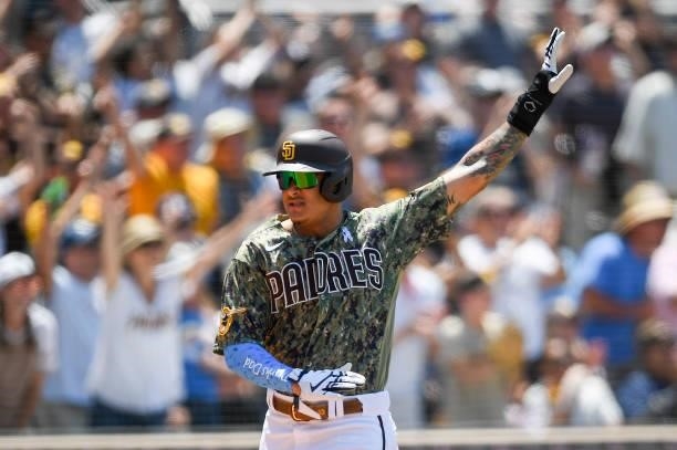 Manny Machado of the San Diego Padres signals as he scores during the third inning of a baseball game against the Cincinnati Reds at Petco Park on...