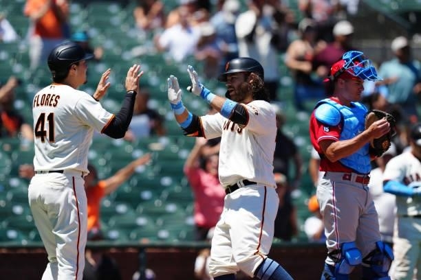 Brandon Crawford of the San Francisco Giants celebrates hitting a home run with Wilmer Flores during the game between the Philadelphia Phillies and...