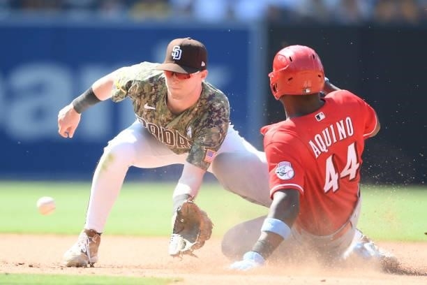 Aristides Aquino of the Cincinnati Reds steals second base ahead to the throw to Jake Cronenworth of the San Diego Padres during the eighth inning of...