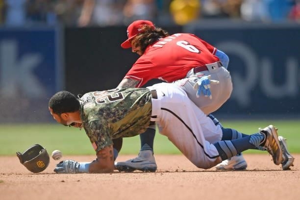 Tommy Pham of the San Diego Padres slides into second base with a double ahead of the throw to Jonathan India of the Cincinnati Reds in the seventh...