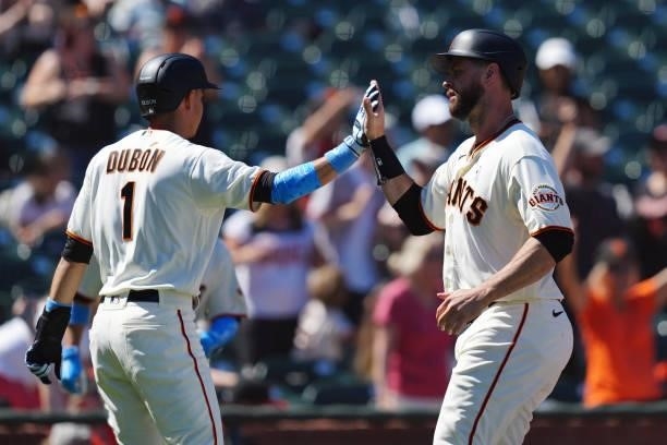 Mauricio Dubón of the San Francisco Giants and Brandon Belt celebrate both scoring during the game between the Philadelphia Phillies and the San...