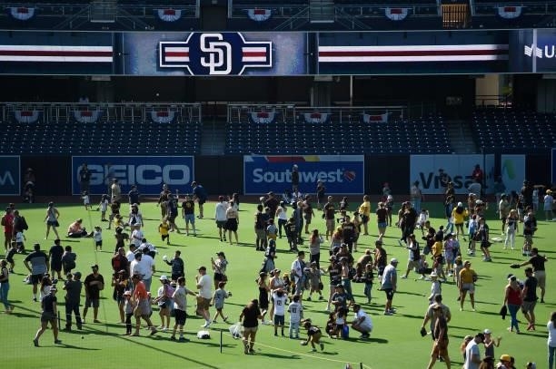 Fans and their children play on the field after a baseball game between the San Diego Padres and the Cincinnati Reds at Petco Park on June 20, 2021...