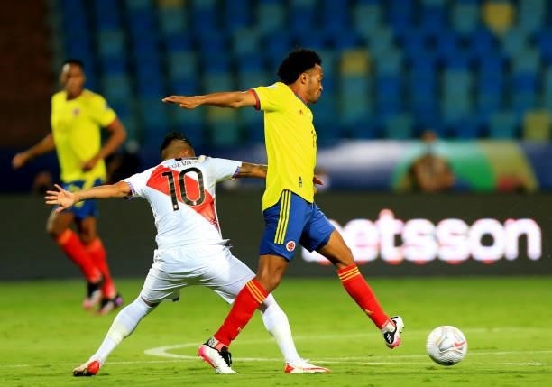 Juan Cuadrado of Colombia competes for the ball with Christian Cueva of Peru during the match between Colombia and Peru as part of Conmebol Copa...