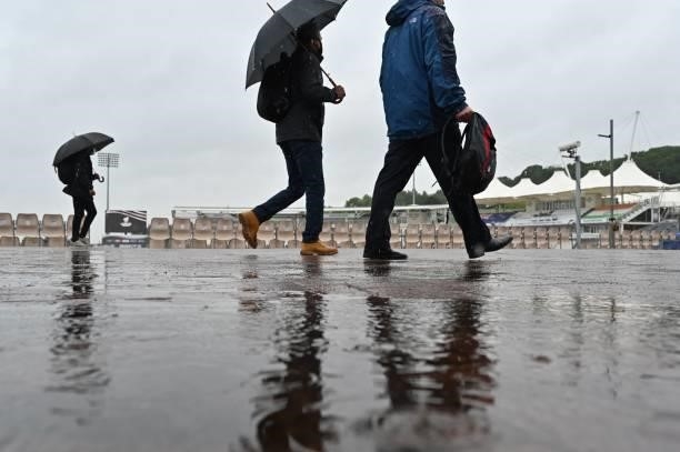 Indian fans walk in the rain on the fourth day of the ICC World Test Championship Final between New Zealand and India at the Ageas Bowl in...