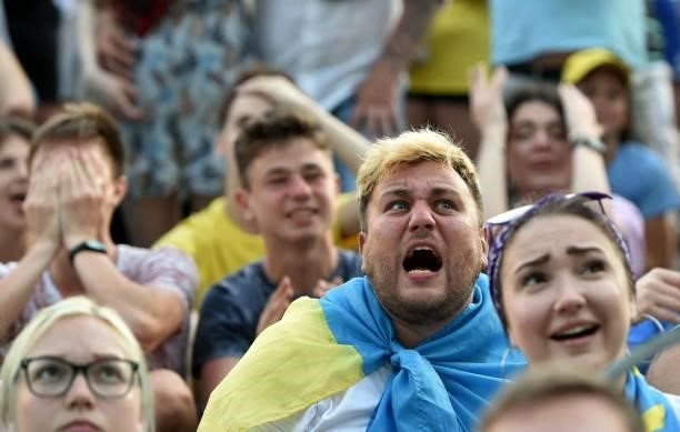 Ukrainian supporters react as they watch the UEFA EURO 2020 Group C football match between the Ukraine and Austria on a giant screen of the fanzone...