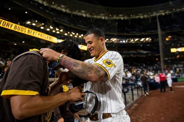 Manny Machado of the San Diego Padres places the 'swag chain' on Yu Darvish after defeating the Los Angeles Dodgers on June 21, 2021 at Petco Park in...