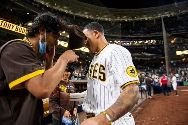 Manny Machado of the San Diego Padres places the 'swag chain' on Yu Darvish after defeating the Los Angeles Dodgers on June 21, 2021 at Petco Park in...