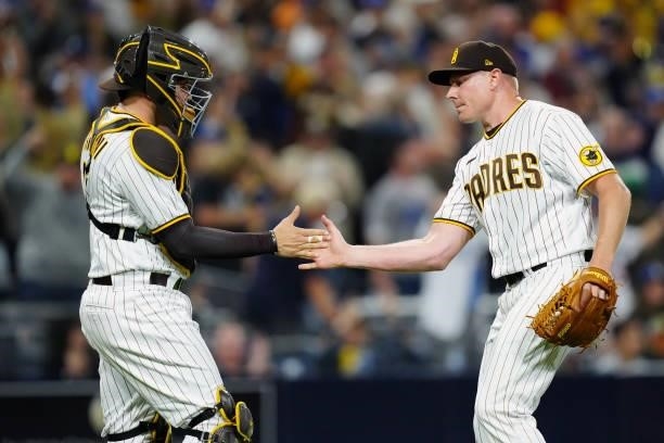 Mark Melancon and Victor Caratini of the San Diego Padres celebrate after the Padres defeated the Los Angeles Dodgers at Petco Park on Tuesday, June...