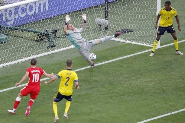 Sweden's goalkeeper Robin Olsen dives after Poland's forward Robert Lewandowski headed the ball and hit the goal post during the UEFA EURO 2020 Group...
