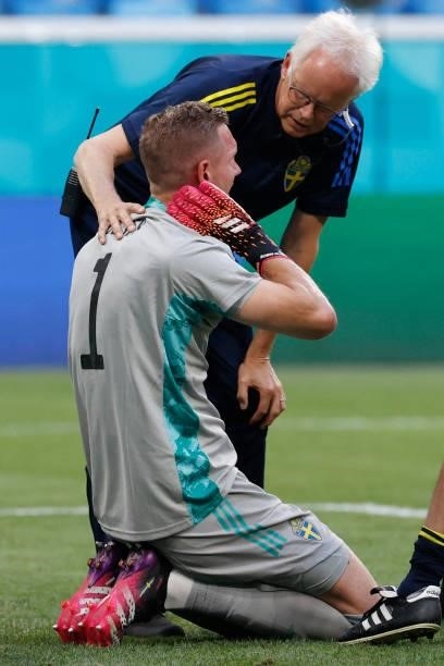 Sweden's goalkeeper Robin Olsen receives medical attention during the UEFA EURO 2020 Group E football match between Sweden and Poland at Saint...