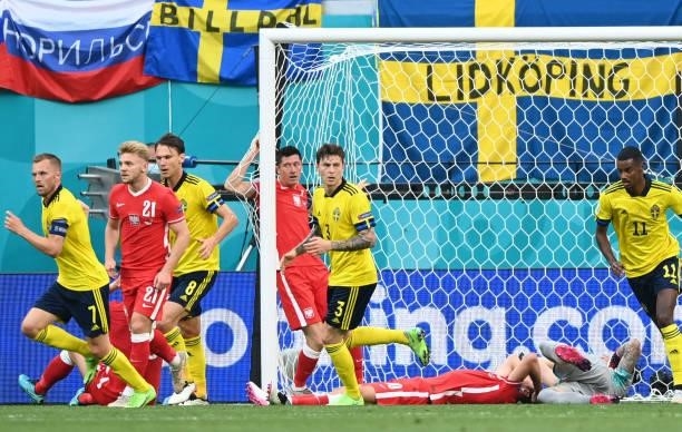 Poland's forward Robert Lewandowski and Poland's midfielder Grzegorz Krychowiak react after missing a goal opportunity during the UEFA EURO 2020...