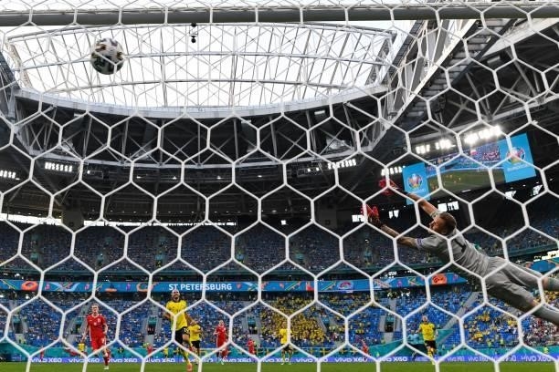 Sweden's goalkeeper Robin Olsen jumps and concedes Poland's first goal scores by Poland's forward Robert Lewandowski during the UEFA EURO 2020 Group...