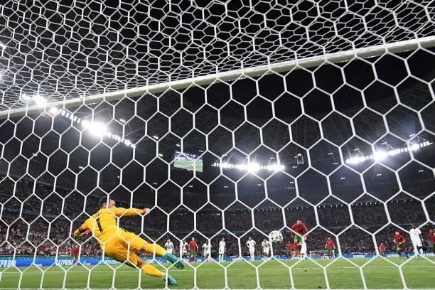 Portugal's forward Cristiano Ronaldo scores the opening goal from the penalty spot past France's goalkeeper Hugo Lloris during the UEFA EURO 2020...