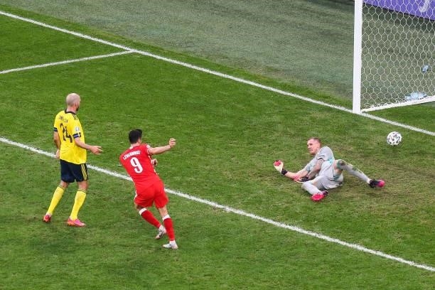Poland's forward Robert Lewandowski shoots and scores his team's second goal to Robin Olsen of Sweden during the UEFA EURO 2020 Group E football...