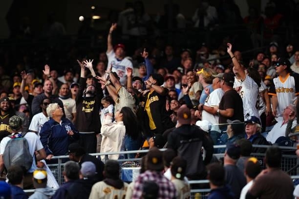 Fans try to catch a ball during the game between the Los Angeles Dodgers and the San Diego Padres at Petco Park on Wednesday, June 23, 2021 in San...