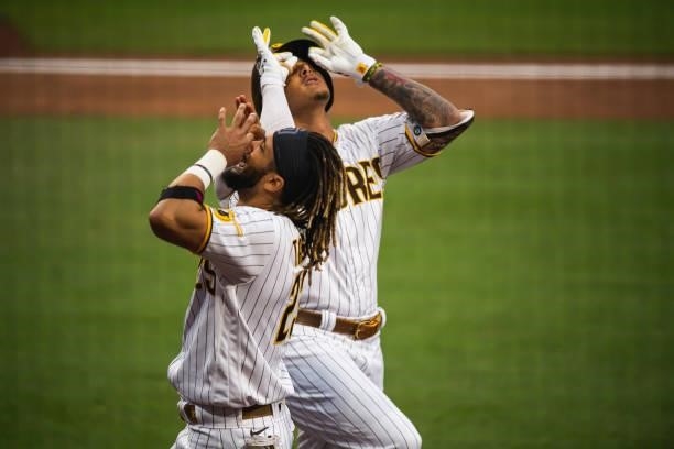 Manny Machado of the San Diego Padres celebrates with Fernando Tatis Jr after hitting a home run in the first inning against the Los Angeles Dodgers...
