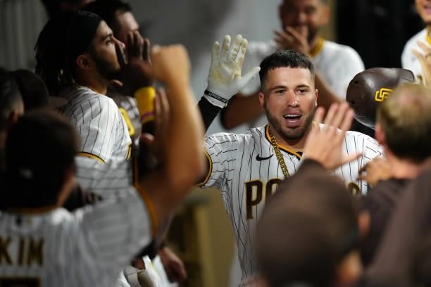 Victor Caratini of the San Diego Padres celebrates in the dugout after hitting a home run during the game between the Los Angeles Dodgers and the San...