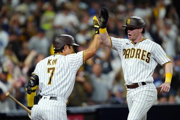 Ha-Seong Kim of the San Diego Padres high fives Jake Cronenworth after Cronenworth scored the go-ahead run during the game between the Los Angeles...