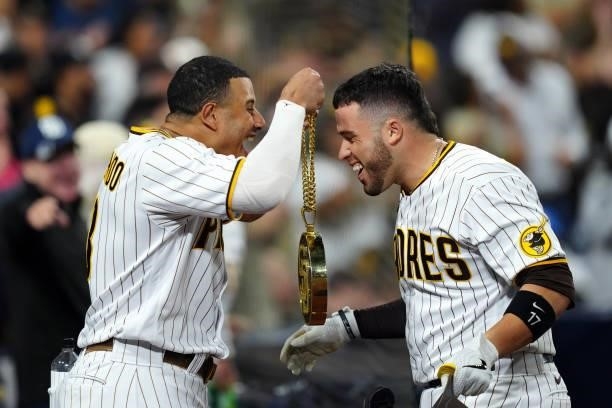 Manny Machado of the San Diego Padres celebrates with Victor Caratini after Caratini hit a home run during the game between the Los Angeles Dodgers...