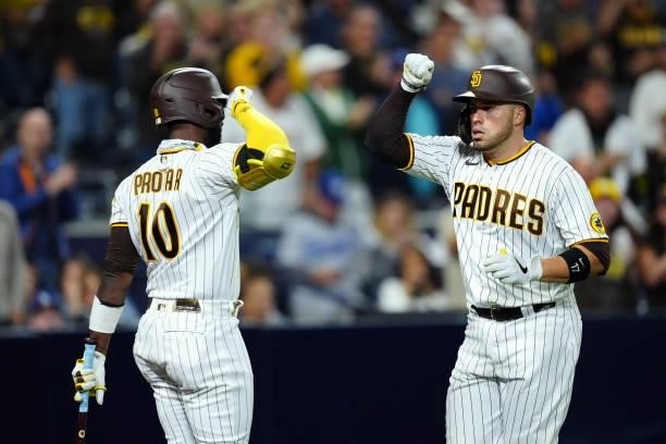 Jurickson Profar of the San Diego Padres celebrates with Victor Caratini after Caratini hit a home run during the game between the Los Angeles...