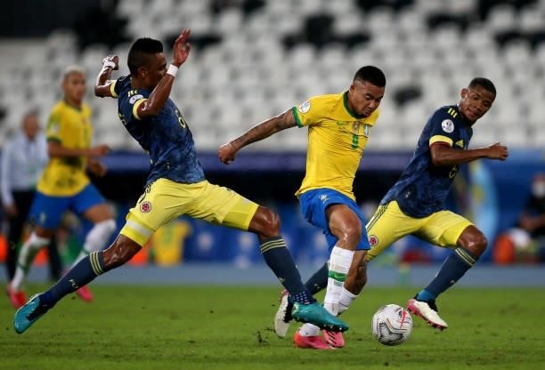 Gabriel Jesus of Brazil competes for the ball with William Tesillo and Wilmar Barrios of Colombia during the match between Brazil and Colombia as...