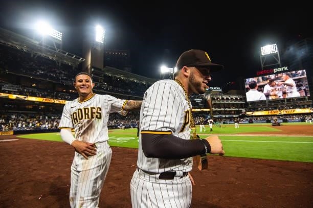 Manny Machado of the San Diego Padres places the 'swag chain' on Victor Caratini after defeating the Los Angeles Dodgers on June 23, 2021 at Petco...