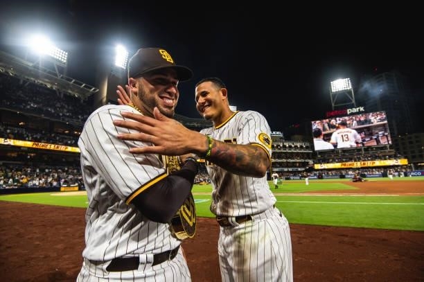 Manny Machado of the San Diego Padres places the 'swag chain' on Victor Caratini after defeating the Los Angeles Dodgers on June 23, 2021 at Petco...