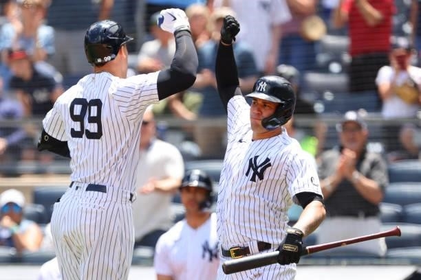 Aaron Judge of the New York Yankees high fives Gary Sanchez after he hit a home run against the Kansas City Royals during the first inning of a game...