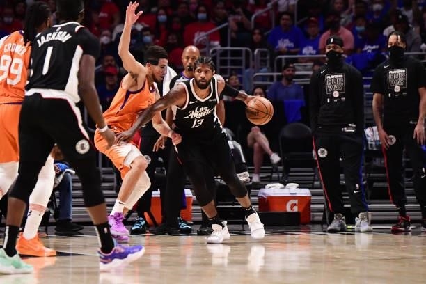 Paul George of the LA Clippers handles the ball as Devin Booker of the Phoenix Suns plays defense during the game during Game 3 of the Western...
