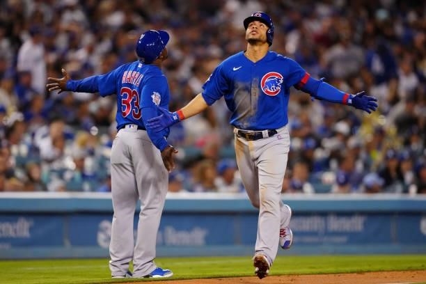 Willson Contreras of the Chicago Cubs celebrates with Third Base Coach Willie Harris after hitting a home run during the game between the Chicago...