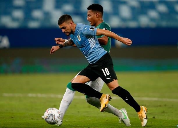 Giorgian De Arrascaeta of Uruguay competes for the ball with Jairo Quinteros of Bolivia ,during the match between Bolivia and Uruguay as part of...