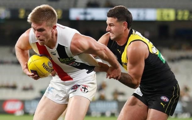 Sebastian Ross of the Saints is tackled by Jack Graham of the Tigers during the 2021 AFL Round 15 match between the Richmond Tigers and the St Kilda...